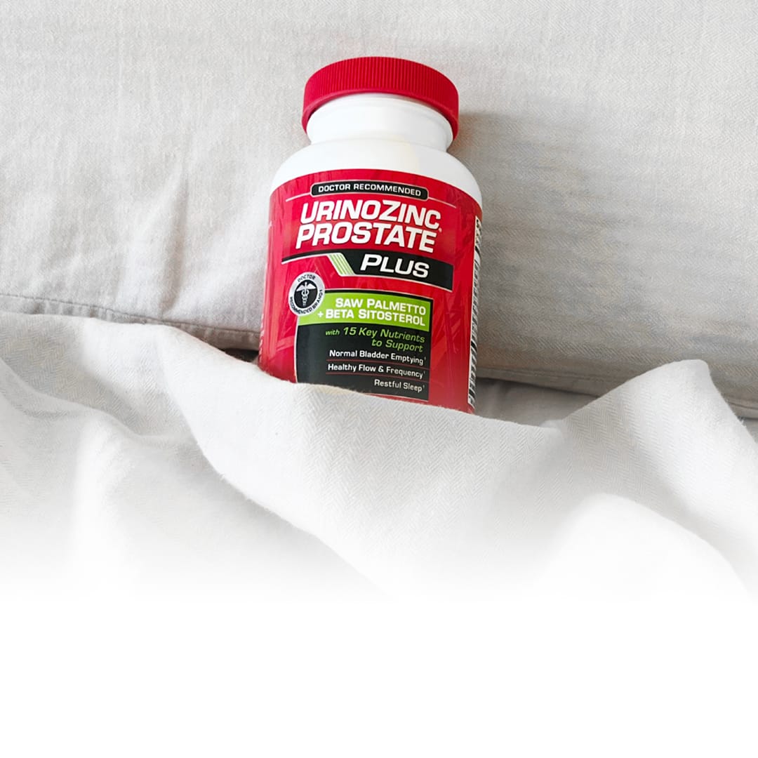 a bottle of UrinoZinc a bed with a blanket partially covering the bottle